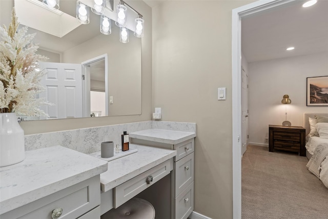 bathroom with a skylight, vanity, and baseboards