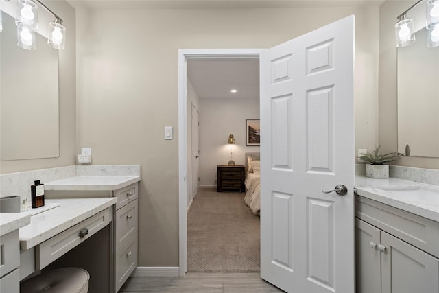 full bathroom with connected bathroom, vanity, and baseboards