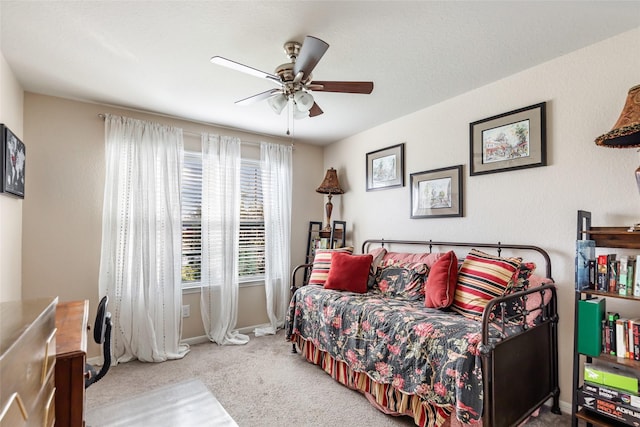 carpeted bedroom with a ceiling fan and baseboards