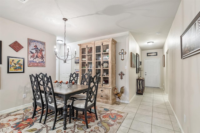 dining room featuring light tile patterned flooring, a notable chandelier, and baseboards