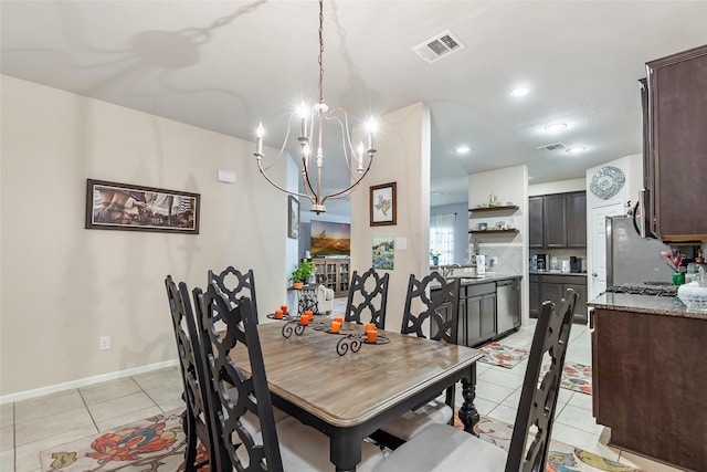 dining room featuring light tile patterned floors, baseboards, visible vents, and a notable chandelier