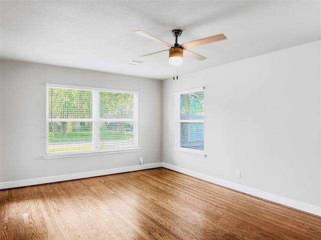 empty room featuring ceiling fan, baseboards, and wood finished floors