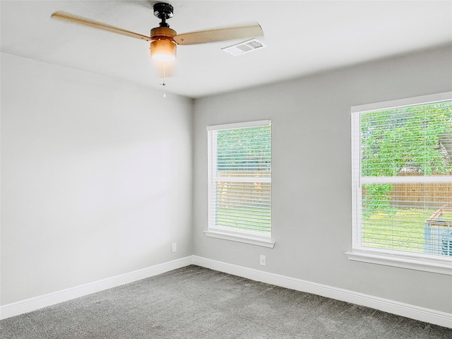 carpeted empty room featuring baseboards, visible vents, and a wealth of natural light