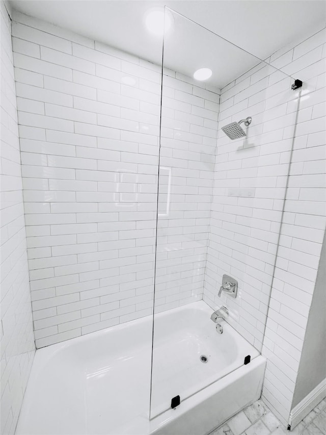 full bath featuring marble finish floor and  shower combination