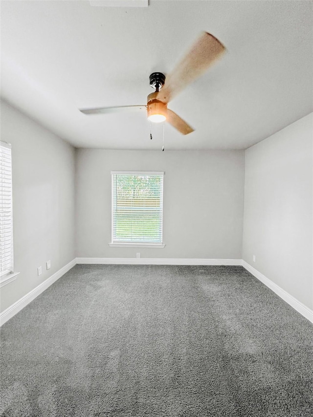 spare room featuring carpet floors, a ceiling fan, and baseboards