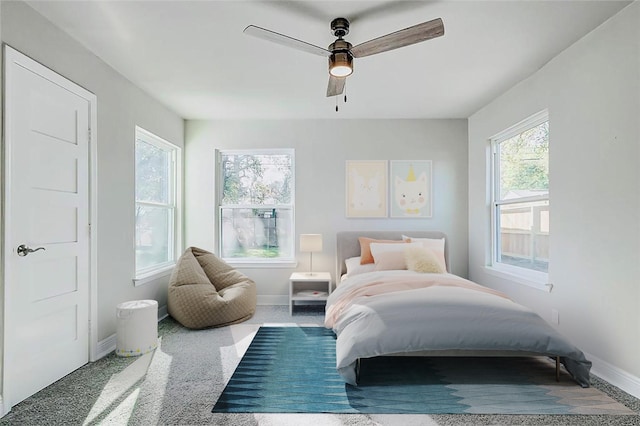 carpeted bedroom with a ceiling fan and baseboards