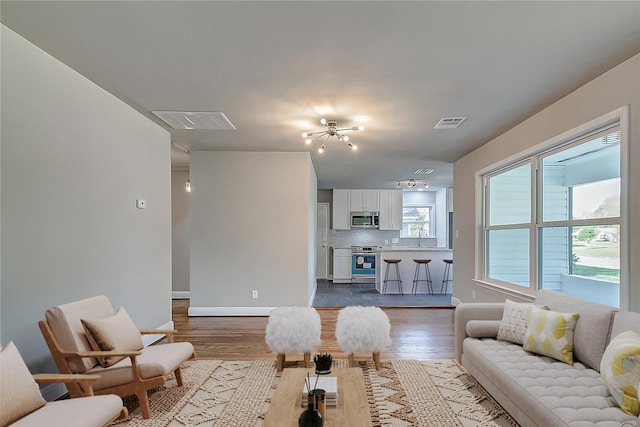 living area with dark wood-style floors, baseboards, and visible vents