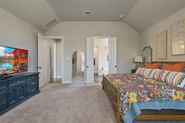 bedroom with visible vents, lofted ceiling, arched walkways, baseboards, and light colored carpet