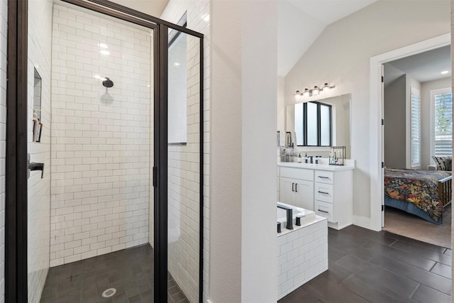 bathroom featuring connected bathroom, baseboards, vaulted ceiling, a stall shower, and vanity