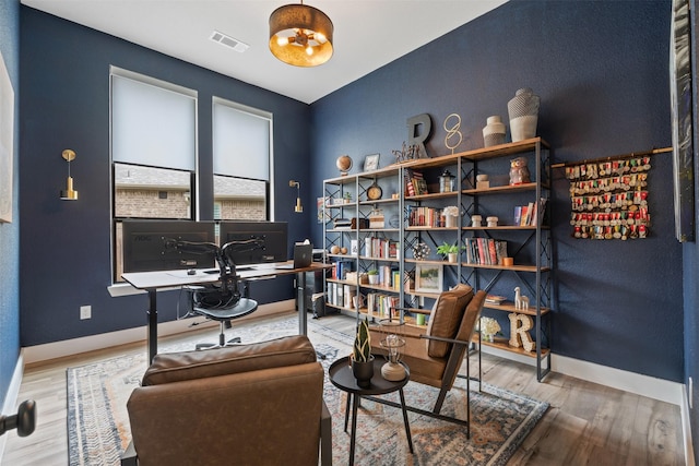 office area featuring visible vents, baseboards, and wood finished floors