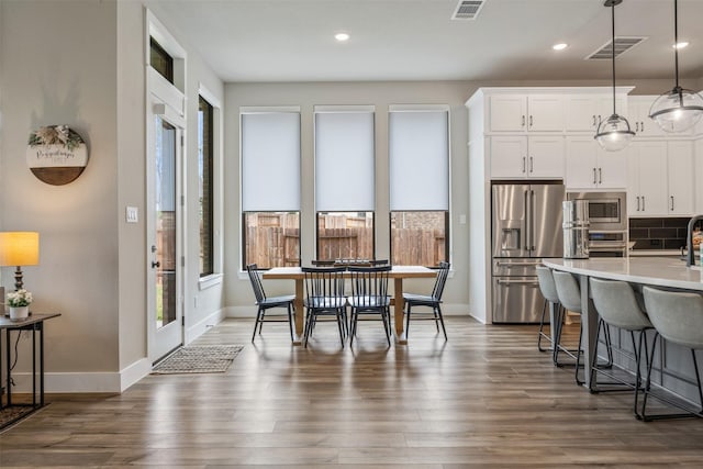 dining area featuring visible vents, baseboards, and dark wood-type flooring