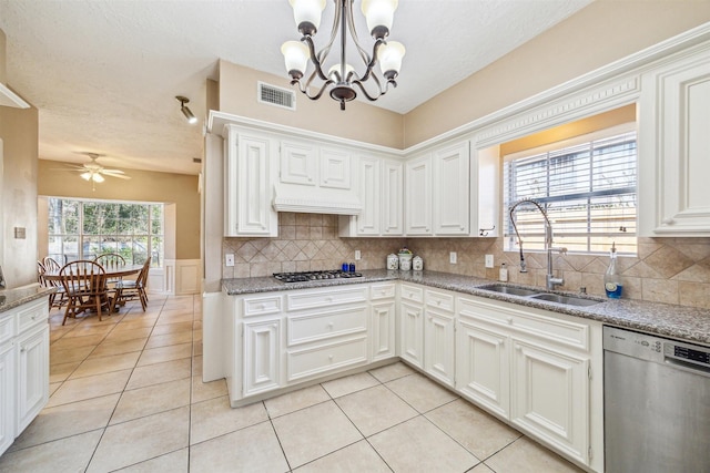 kitchen with light tile patterned floors, stainless steel dishwasher, a sink, and visible vents