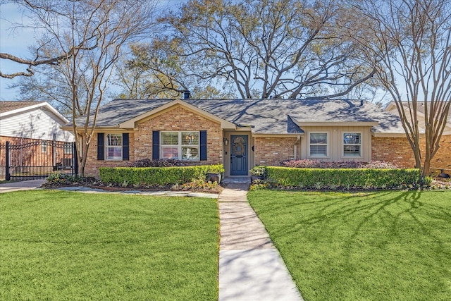 ranch-style home with a front yard, fence, and brick siding