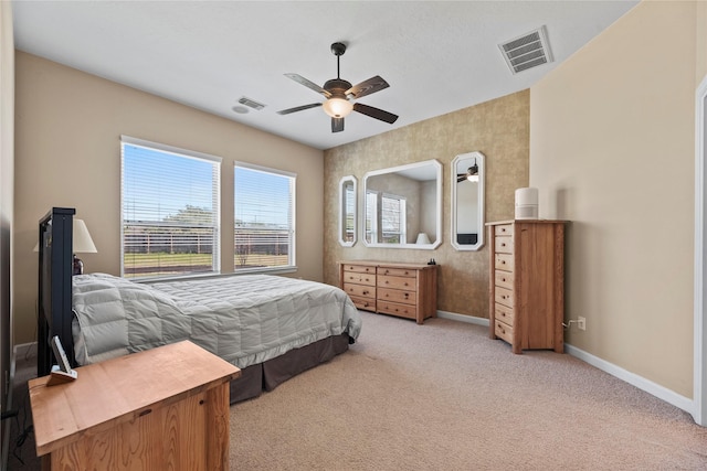 bedroom featuring light carpet, a ceiling fan, visible vents, and baseboards