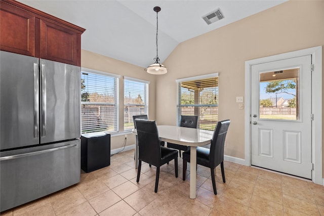 dining area featuring light tile patterned floors, baseboards, visible vents, and vaulted ceiling