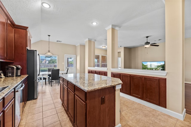 kitchen featuring lofted ceiling, stainless steel appliances, a kitchen island, light stone countertops, and ornate columns