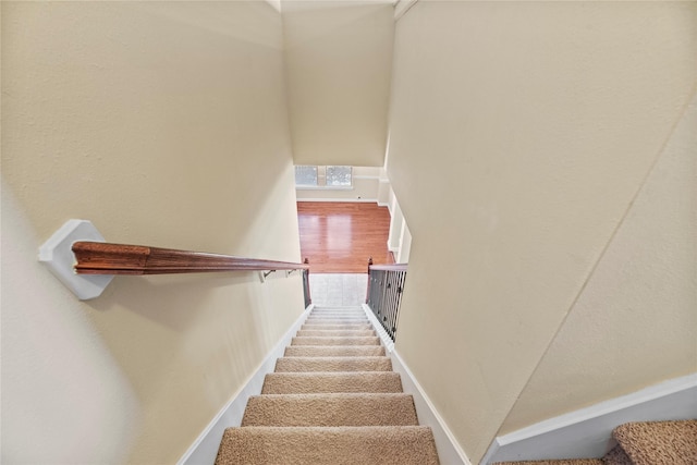 stairway featuring baseboards and visible vents