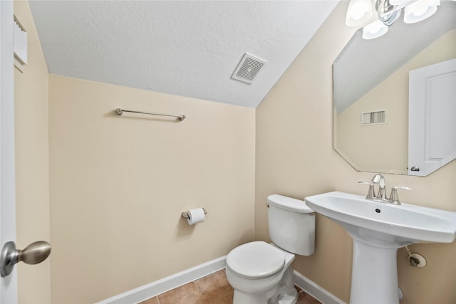 half bathroom featuring toilet, baseboards, visible vents, and lofted ceiling