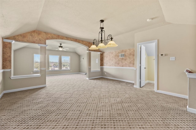 unfurnished room featuring lofted ceiling, light carpet, arched walkways, and visible vents