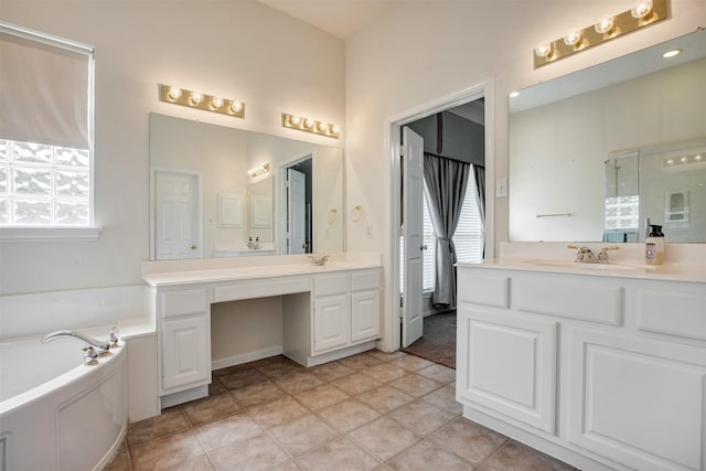 bathroom with a bath, two vanities, and a sink