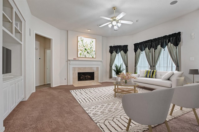 carpeted living area featuring ceiling fan, a fireplace, a wealth of natural light, and baseboards