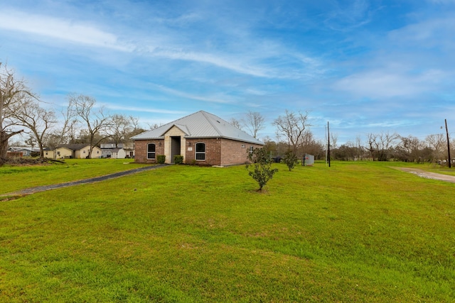 view of front of property featuring brick siding, driveway, and a front lawn