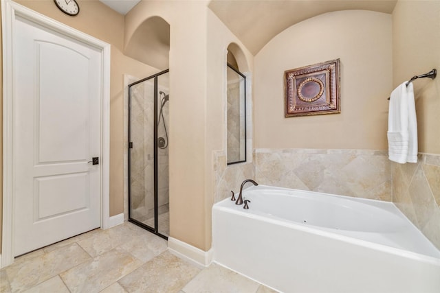 full bath featuring a garden tub, a shower stall, and baseboards