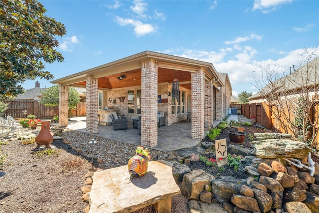 exterior space with brick siding, a patio area, and a fenced backyard