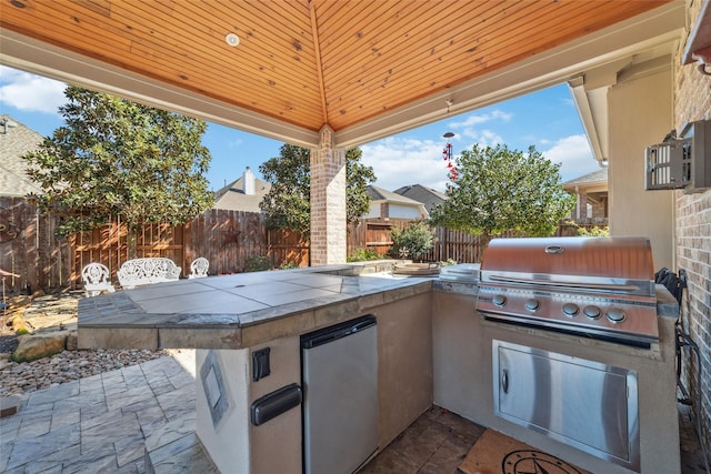 view of patio with area for grilling and a fenced backyard