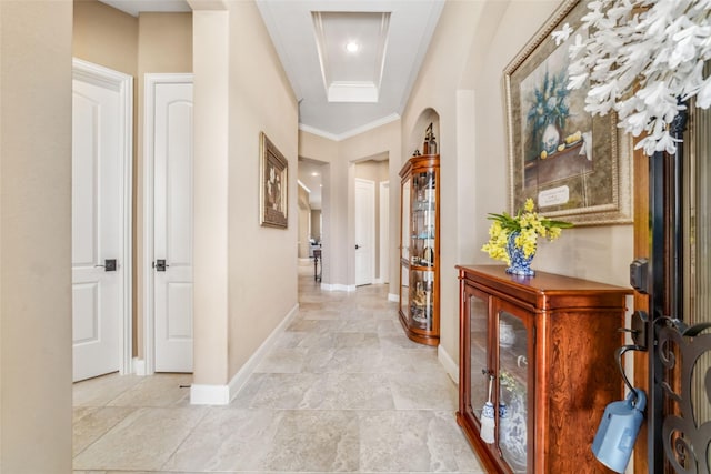 corridor with ornamental molding, arched walkways, and baseboards