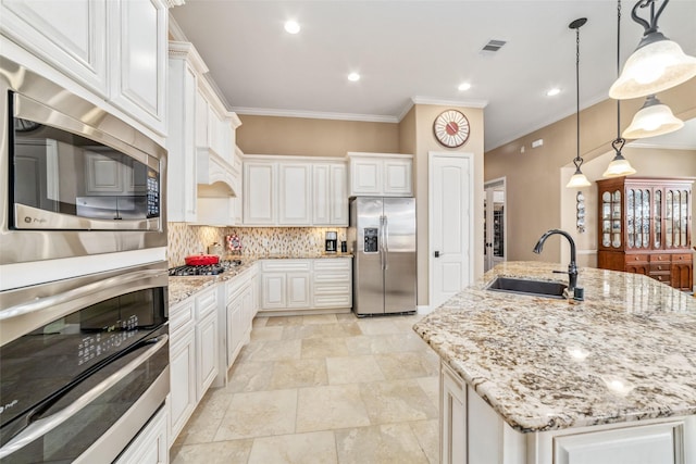 kitchen featuring a sink, white cabinetry, appliances with stainless steel finishes, backsplash, and pendant lighting