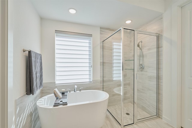 full bathroom featuring recessed lighting, a freestanding tub, a healthy amount of sunlight, and a shower stall