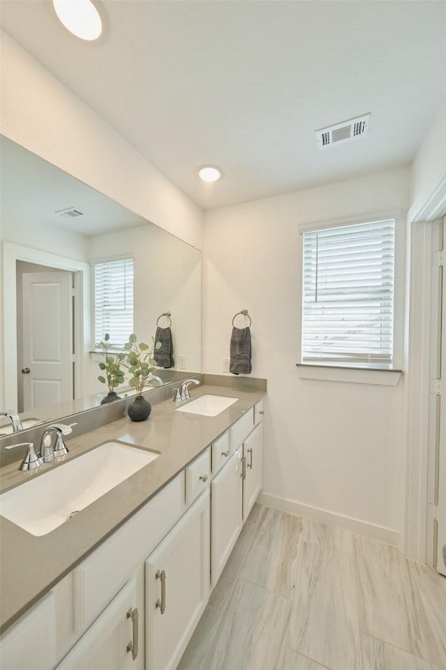 full bathroom with visible vents, a sink, baseboards, and double vanity