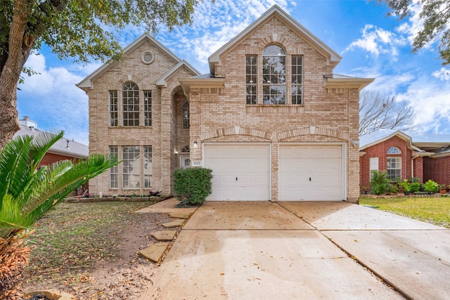 traditional-style home featuring a garage, brick siding, and driveway