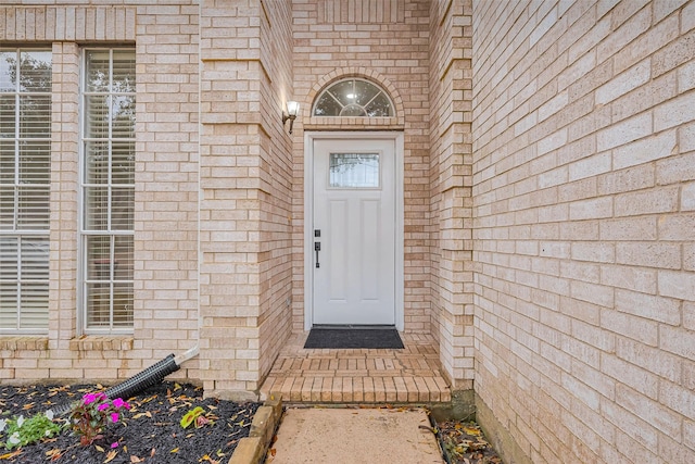 property entrance featuring brick siding