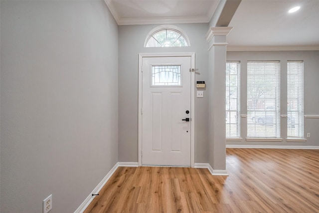 entrance foyer with baseboards, ornamental molding, light wood-type flooring, and ornate columns