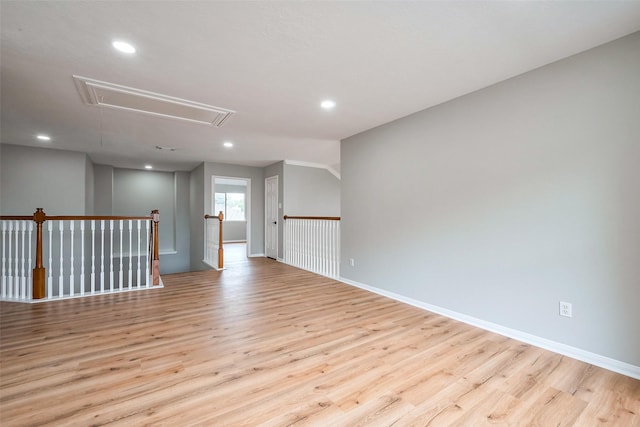 empty room with light wood finished floors, attic access, and recessed lighting