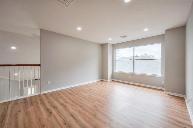 empty room featuring light wood finished floors, baseboards, visible vents, and recessed lighting