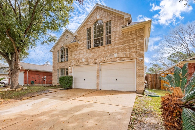 traditional home featuring driveway, a garage, fence, and brick siding