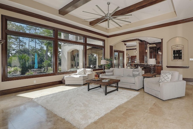 living area with a ceiling fan, arched walkways, beam ceiling, and baseboards