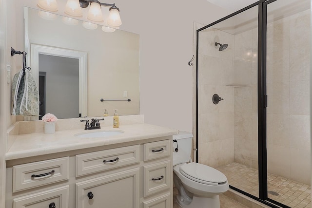 bathroom with a stall shower, vanity, and toilet