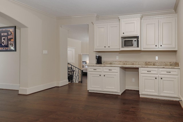 kitchen featuring ornamental molding, stainless steel microwave, dark wood finished floors, and white cabinetry