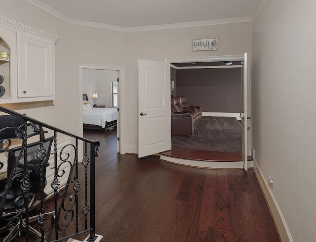 corridor with ornamental molding, dark wood finished floors, an upstairs landing, and baseboards