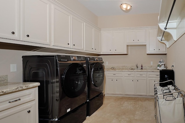 laundry room with a sink, washing machine and clothes dryer, and cabinet space