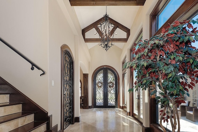 entryway with arched walkways, high vaulted ceiling, stairs, french doors, and beam ceiling