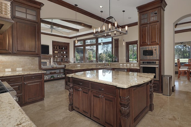 kitchen with stainless steel appliances, plenty of natural light, backsplash, and a center island