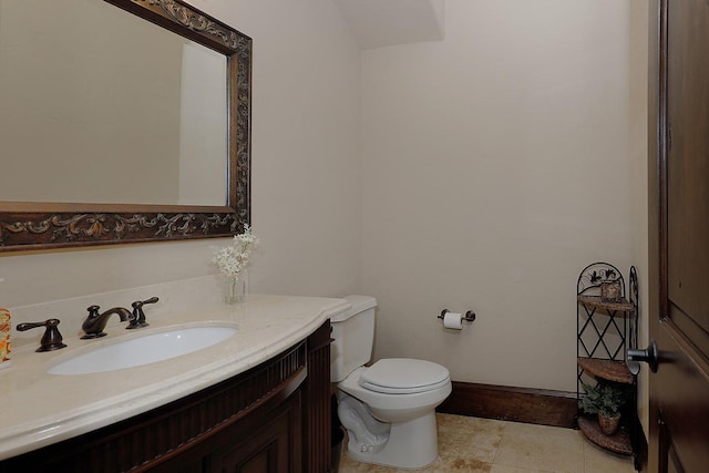 bathroom featuring toilet, tile patterned flooring, vanity, and baseboards