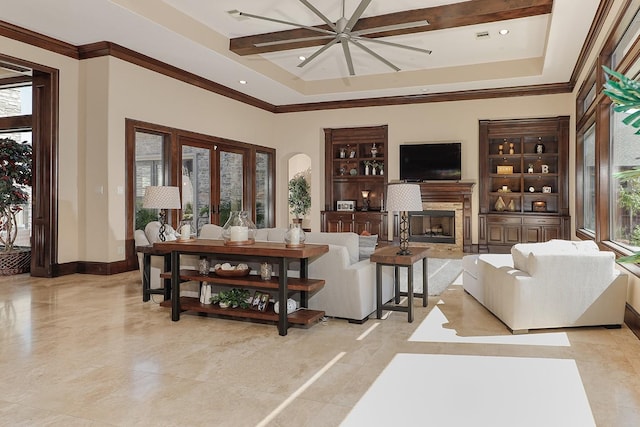 living room featuring a tray ceiling, plenty of natural light, a fireplace, and baseboards