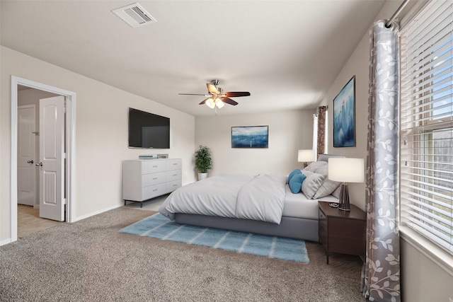 carpeted bedroom with baseboards, visible vents, and a ceiling fan