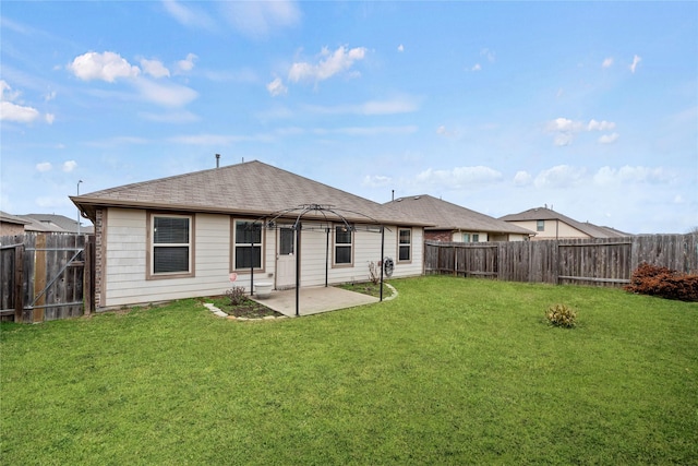 back of house with roof with shingles, a lawn, a gazebo, a patio area, and a fenced backyard